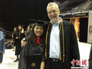 中国留学生获白宫记者协会奖。5月12日，胡斯羽在密苏里大学新闻学院毕业典礼上与导师合影
