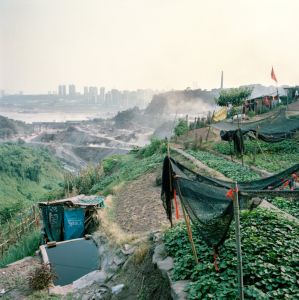 在重庆的未开发地区，农民的土地紧邻建筑工地。