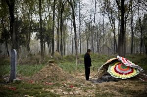 西平县张金堂村，86岁的王慎思因食道癌去世，他的坟头还摆放着花圈。
