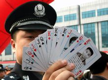 警察展示印有被通缉逃犯头像的扑克牌
