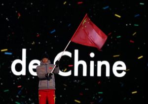 5.图为中国代表团旗手朱朕宇在开幕式上挥舞五星红旗。（图片来源：新华社）