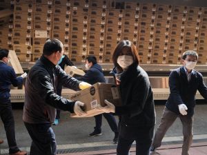 2020年4月11日，在日本大阪，中国驻大阪总领馆的工作人员搬运“健康包”的物资。